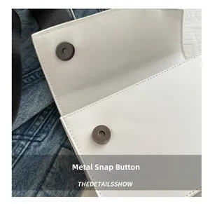 Detail of white leather bag featuring a high-quality magnetic buckle and neat stitching
