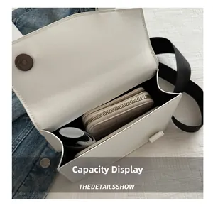 Detail showing the internal capacity of the ivory white square bag with wide strap