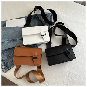 Detailed flat lay of minimalist square bags in white, brown and black with wide straps
