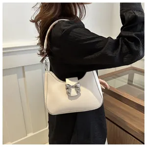 Seitenansicht einer weißen Halbmond-Schultertasche mit silberner Metallschleife-Schnalle
