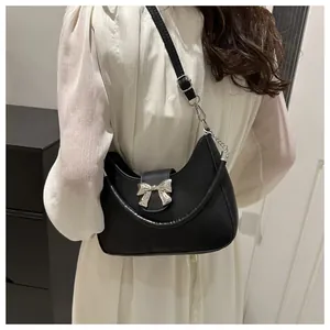 Detail einer schwarzen Halbmond-Handtasche mit silberner Metallelement-Schleife