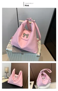 Pink soft PU shoulder bag detail showing silver bow and textured material on luggage