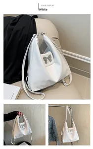 Detail of soft white PU leather handbag featuring a silver metallic butterfly clasp buckle