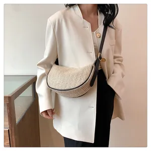 Chic beige woven crescent bag featuring a dark leather strap and gold metal hardware
