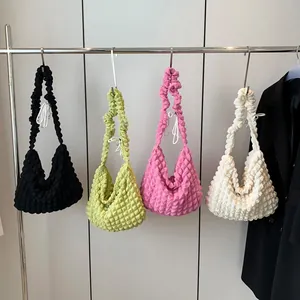 Quilted bubble texture tote bags in black, lime, pink and white on a metal hanger