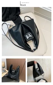 Detail of soft black PU shoulder bag featuring a decorative silver metallic bow accent