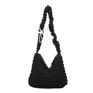 Black popcorn fabric cloud bag with white bow knot detail and large capacity shoulder strap