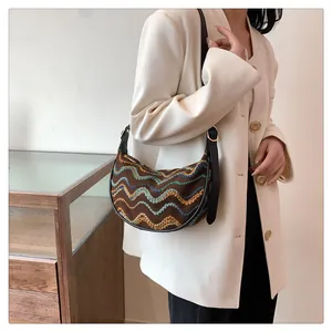 Detail of hobo bag with colorful wave embroidery and leather strap with gold buckle