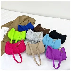 Macro shot of colorful felt underarm bags featuring V-shaped quilting and gold chain link