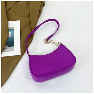 Detail of purple felt underarm bag featuring V-shaped quilting and golden chain strap