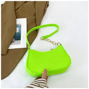 Detail of neon green felt underarm bag with diagonal quilting and gold chain strap