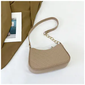 Detail view of the V-shaped quilted stitching and gold chain strap on light brown felt bag