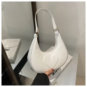 Detailansicht der weißen Hobo-Tasche mit Herzprägung und goldener Metallbeschläge