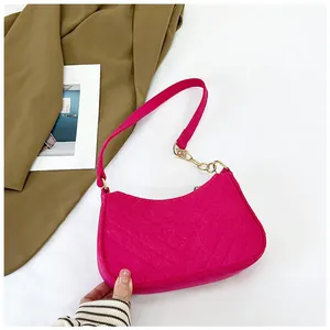 Detail of fuchsia felt hobo bag with V-shaped quilting and golden chain hardware