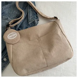 Close-up of khaki corduroy dumpling bag with round coin purse and adjustable strap
