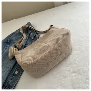 Detail of beige corduroy dumpling bag with matching small round coin purse attachment