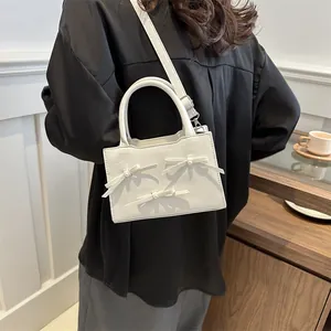 Creamy white crossbody bag with elegant bow and pearl accents for women style