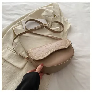 Detalle de bolso silla caqui acolchado con bordados de cadena dorada y correa ajustable