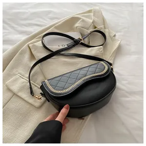 Detalle de bolso silla negro acolchado con ribete de cadena dorada y textura de piel fina