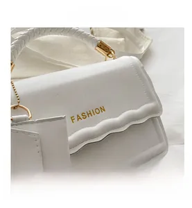 Détail du sac à main blanc avec poignée tressée et rabat festonné au design élégant chic