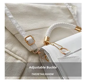 Détail de la poignée tressée blanche et de la boucle dorée ajustable du sac à chaîne