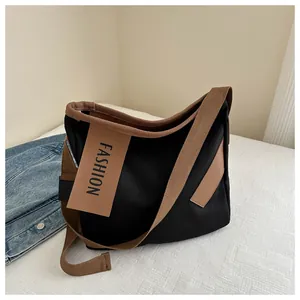 Dettaglio della borsa tote in tela bicolore nero e marrone con ricamo fashion