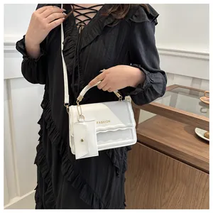 Détail du sac à main blanc avec rabat à volants et petite pochette assortie incluse