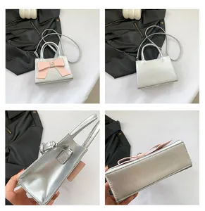 Detail view of silver patent leather mini bag with pink bow and heart charm accents