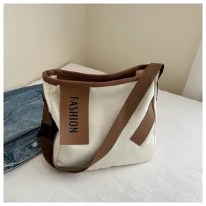 Dettaglio borsa tote in tela con bordo marrone e targhetta decorativa FASHION
