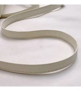 Detailed view of cream white synthetic leather shoulder strap with neat stitching