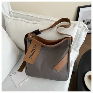 Dettaglio della borsa tote in tela con tracolla regolabile ed etichetta moda