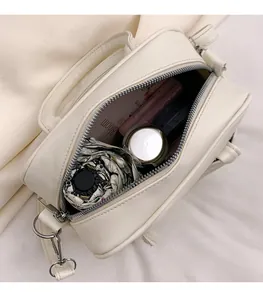 Interior view of beige crossbody bag showing space for cosmetics and a folding umbrella