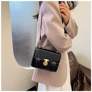 Classic black leather vintage handbag styled with a pink suit in a modern office interior