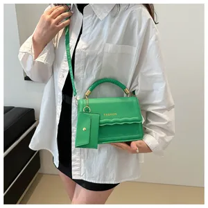 Détail du sac carré vert avec poignée tressée, couture ondulée et logo fashion