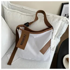 Dettaglio della borsa tote in tela crema con bordo marrone e patch FASHION in rilievo