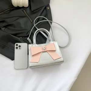 Silver patent leather mini handbag with a pink bow and heart crystal, top handle and strap