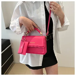 Sac bandoulière rose fuchsia avec coutures ondulées et une petite pochette assortie