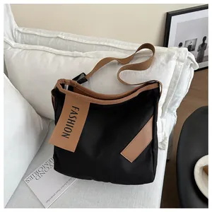 Dettaglio della borsa tote in tela nera con finiture marroni e cartellino FASHION