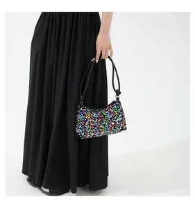 Dettaglio del ricamo di paillettes colorate e fibbia in metallo su una borsa baguette