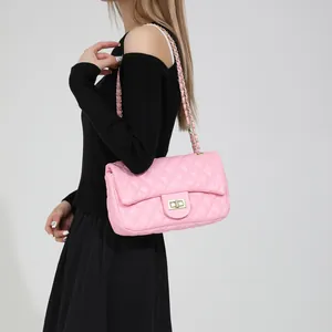 Pink quilted shoulder bag with chain strap and gold twist-lock shown on model