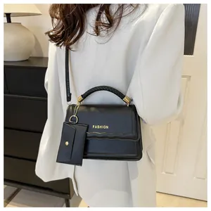 Détail de la poignée tressée et garnitures dorées sur sac bandoulière noir