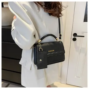 Détail du sac à main noir avec poignée tressée et petit porte-monnaie amovible assorti