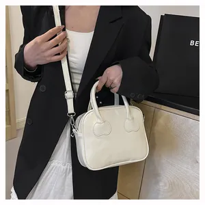 Chic cream white PU leather handbag featuring unique heart-shaped stitching and long strap