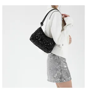Dettaglio della borsa a tracolla con paillettes nere che mostra texture e manico a nodo