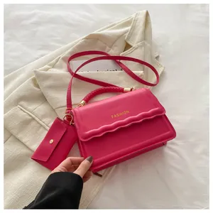 Détail du sac à main fuchsia avec rabat ondulé et mini pochette enveloppe assortie