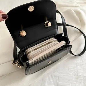 Black vegan leather saddle bag showing interior space for smartphone and wallet