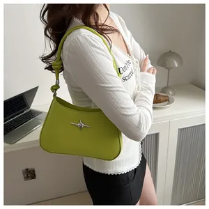 Detail of avocado green leather shoulder bag with star hardware and knotted strap design