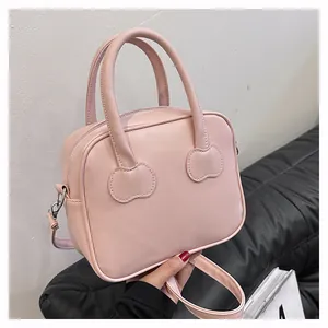 Detail of pink PU leather mini handbag with heart-shaped stitching and silver zipper