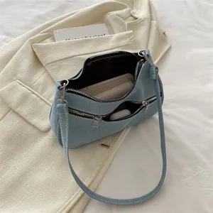 Borsa sottobraccio in denim azzurro con doppia cerniera e tracolla alla moda