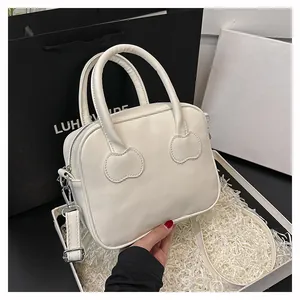 White leather mini handbag with heart-shaped strap patches and silver hardware details